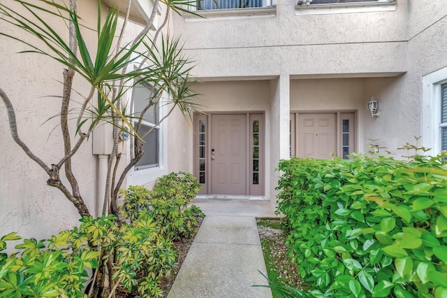 entrance to property featuring stucco siding