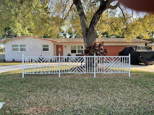 ranch-style home featuring a front yard, stone siding, and a fenced front yard