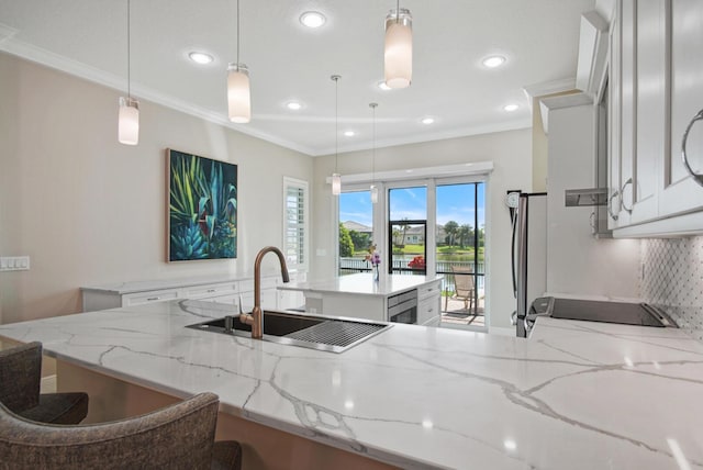 kitchen with a sink, stove, white cabinets, and crown molding