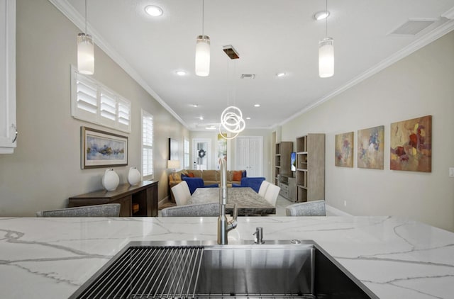 kitchen with light stone counters, visible vents, and crown molding