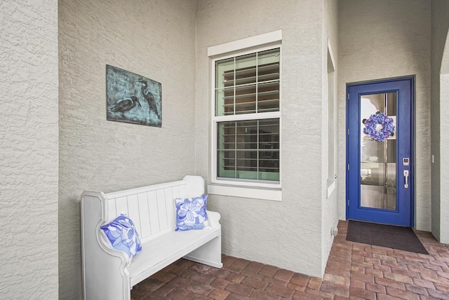 doorway to property featuring stucco siding