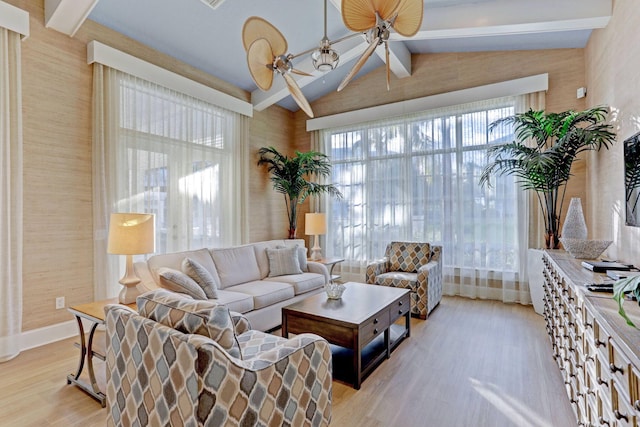 living area featuring vaulted ceiling with beams, a ceiling fan, and light wood finished floors