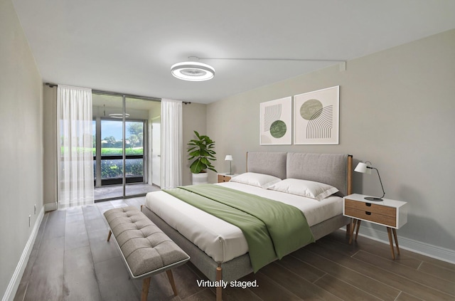 bedroom with access to exterior, floor to ceiling windows, wood finished floors, and baseboards