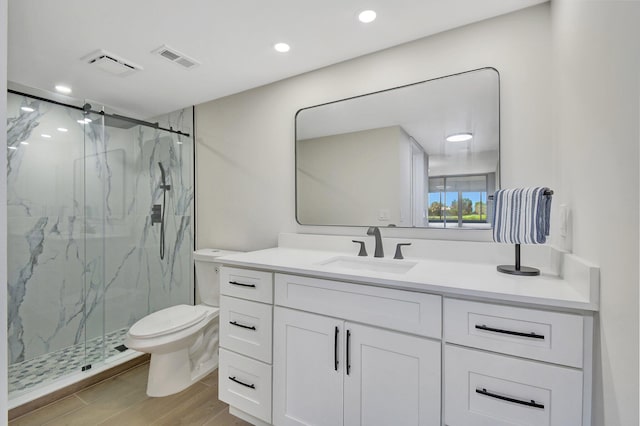 bathroom with a marble finish shower, visible vents, toilet, and vanity