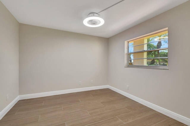 unfurnished room featuring baseboards and wood finished floors