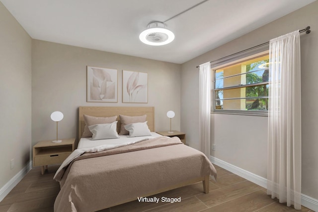 bedroom with baseboards and wood finished floors