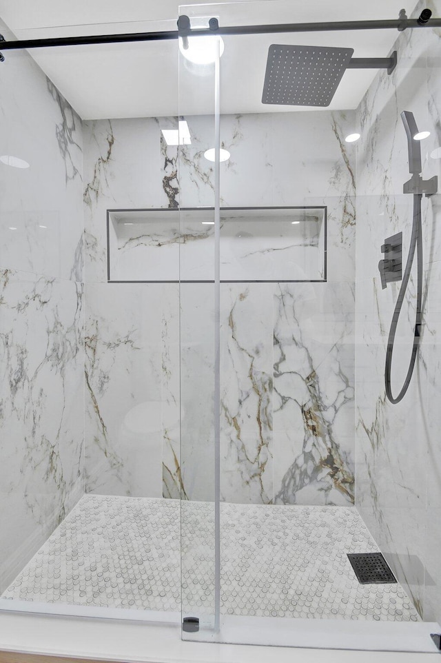 full bathroom featuring a marble finish shower and visible vents