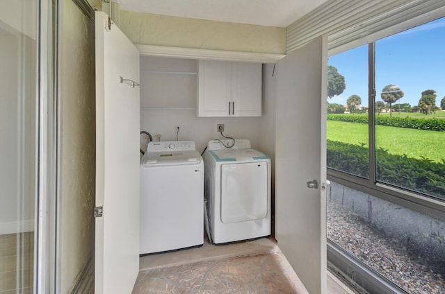 clothes washing area with cabinet space and independent washer and dryer