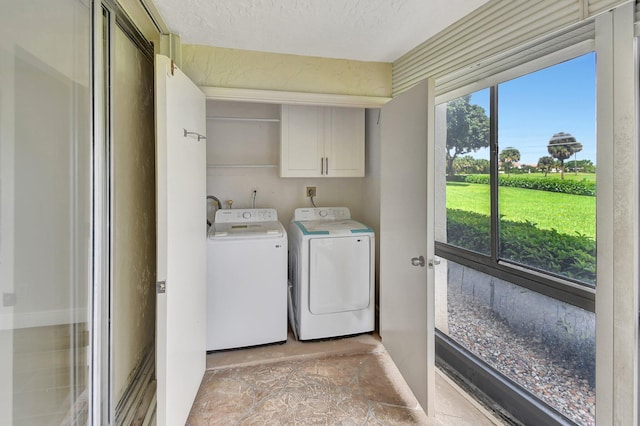 clothes washing area featuring cabinet space, plenty of natural light, independent washer and dryer, and a textured ceiling