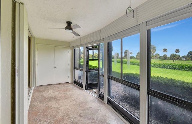 unfurnished sunroom featuring ceiling fan
