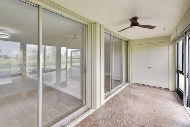 unfurnished sunroom with a ceiling fan