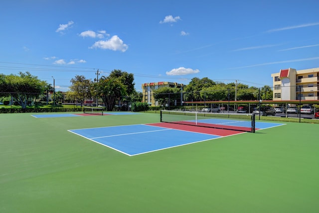 view of tennis court featuring community basketball court and fence