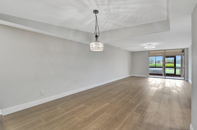 unfurnished room featuring baseboards and wood finished floors