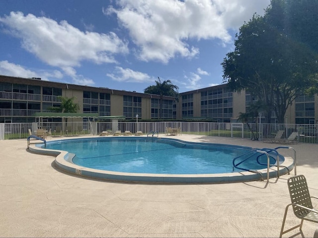 community pool featuring a patio and fence