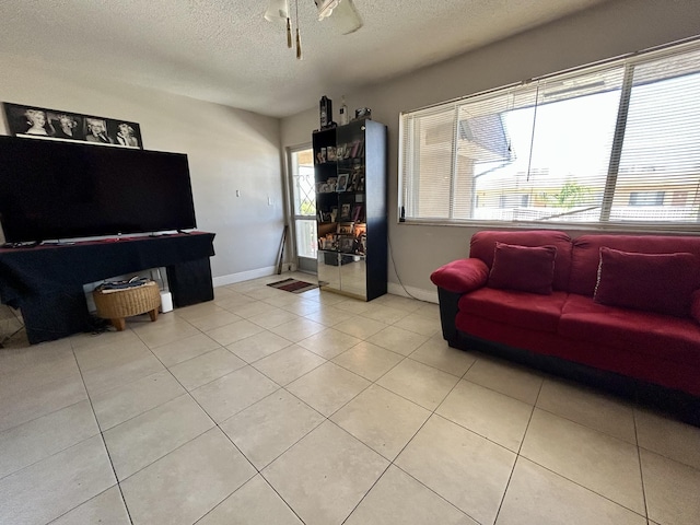 living room with baseboards, a textured ceiling, and light tile patterned flooring