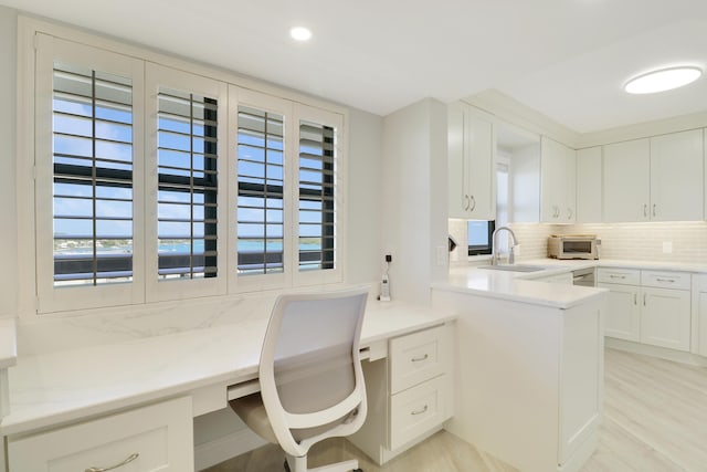 home office with recessed lighting, built in study area, light wood-type flooring, and a sink