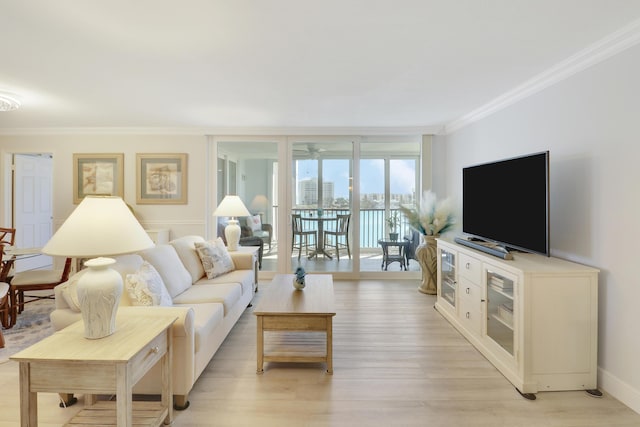 living area featuring crown molding, baseboards, ceiling fan, light wood-type flooring, and expansive windows