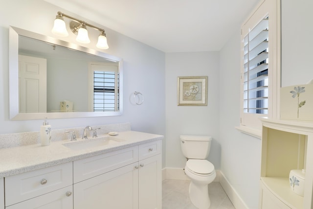 bathroom featuring tile patterned flooring, toilet, vanity, and baseboards