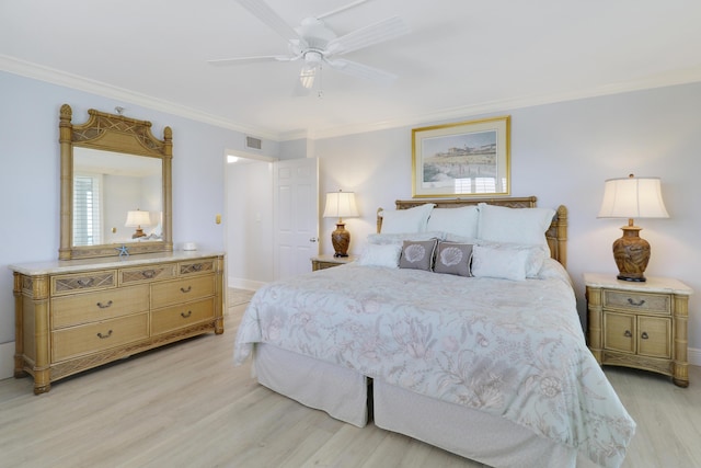 bedroom featuring light wood-type flooring, baseboards, visible vents, and ornamental molding