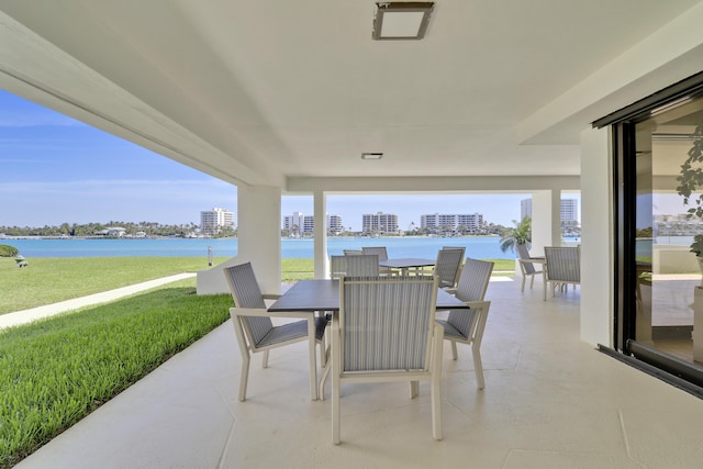 view of patio with outdoor dining area and a water view