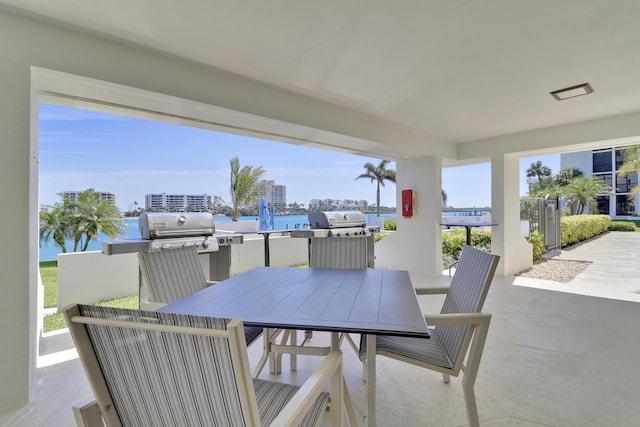 view of patio with outdoor dining space, a city view, and a water view