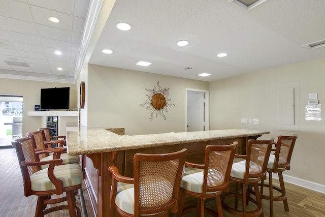 bar with recessed lighting, a bar, and wood finished floors