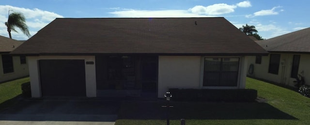 view of front of house with a front yard, a garage, and driveway