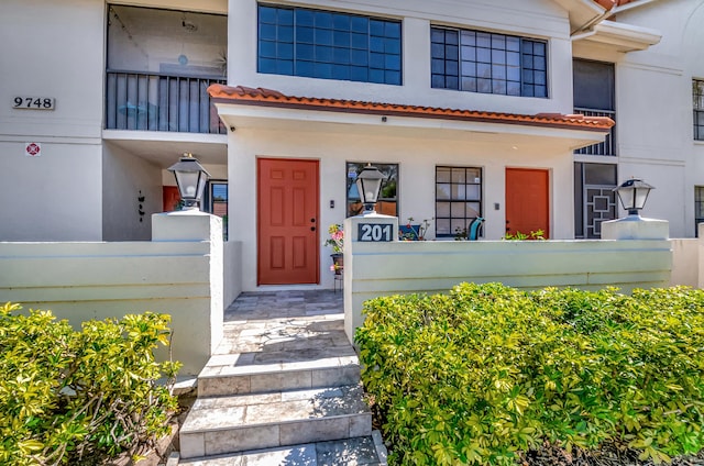 view of front of home featuring stucco siding and a tile roof