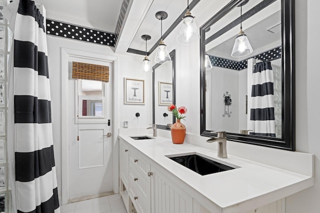 bathroom with tile patterned flooring, double vanity, a shower with curtain, and a sink