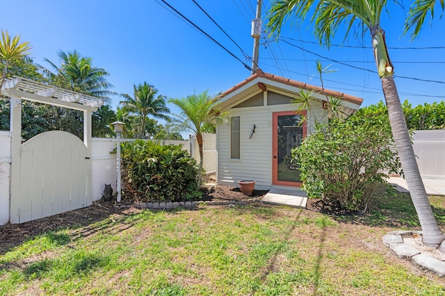 exterior space with an outdoor structure, fence private yard, and a gate