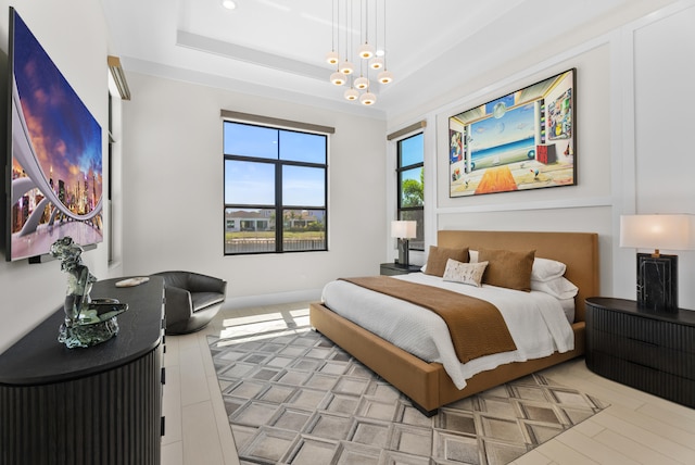 bedroom featuring a chandelier and a tray ceiling