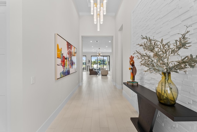 hall with a notable chandelier, recessed lighting, and baseboards