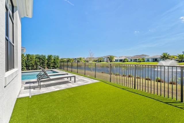 view of yard with a water view, a patio, fence, a residential view, and a fenced in pool