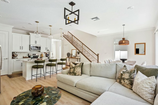4347 Veleiros Ave, Deerfield Beach, FL 33064 - living area with visible vents, ornamental molding, and light wood finished floors