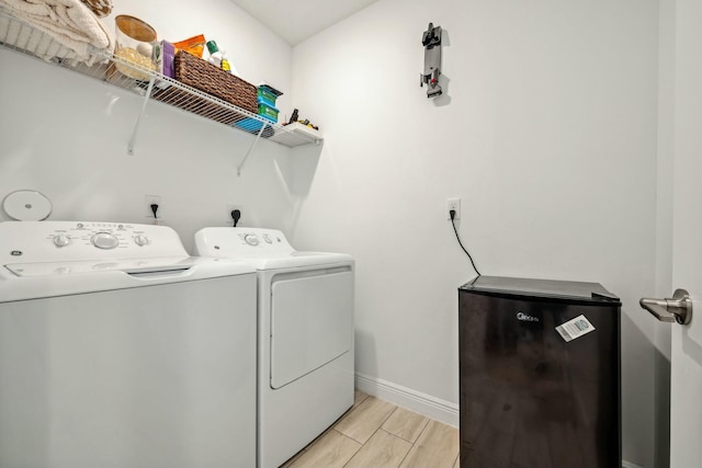 laundry room featuring washer and clothes dryer, laundry area, baseboards, and wood tiled floor