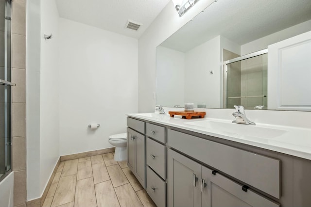 bathroom with a shower with shower door, toilet, visible vents, and a sink