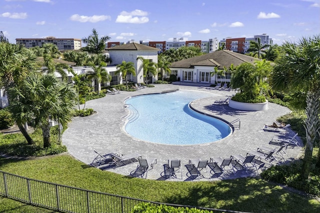 view of swimming pool with a patio area, fence, and a lawn