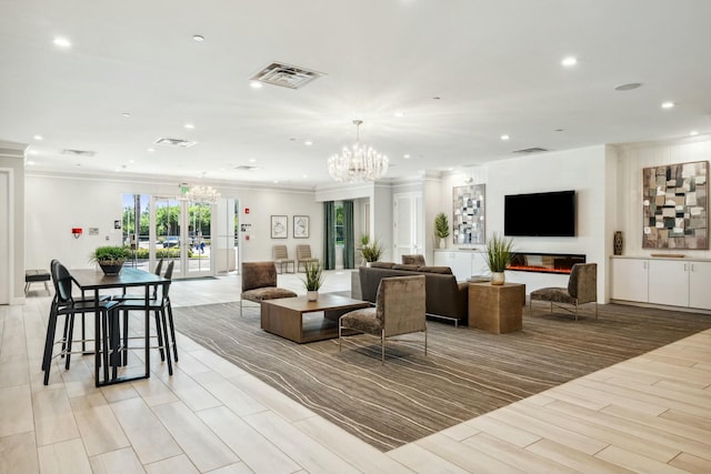 living room featuring a notable chandelier, wood finish floors, visible vents, and ornamental molding