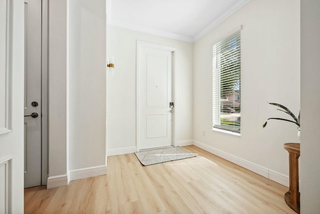 entryway with crown molding, wood finished floors, and baseboards