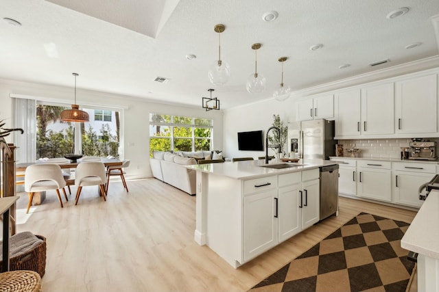 kitchen featuring a sink, light countertops, ornamental molding, and stainless steel appliances