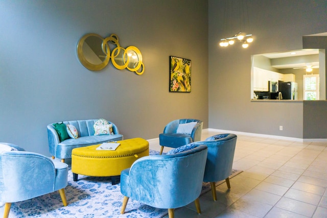 sitting room with tile patterned flooring, baseboards, and ceiling fan