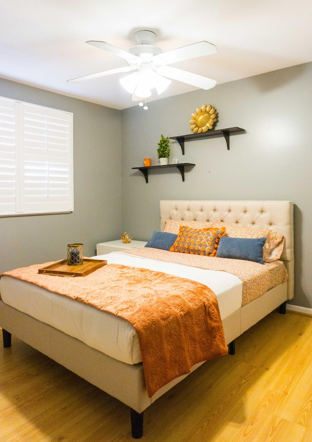 bedroom with light wood-style flooring and a ceiling fan