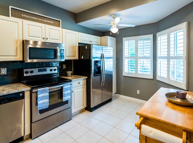 kitchen with decorative backsplash, baseboards, white cabinetry, and appliances with stainless steel finishes