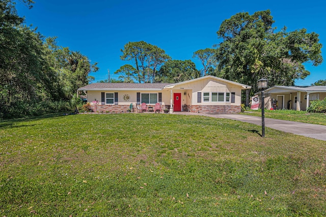 ranch-style home with brick siding, concrete driveway, and a front yard