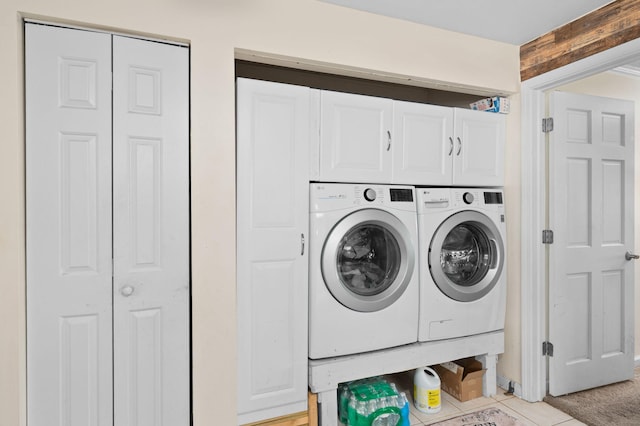 laundry room with washer and dryer, cabinet space, and light tile patterned floors