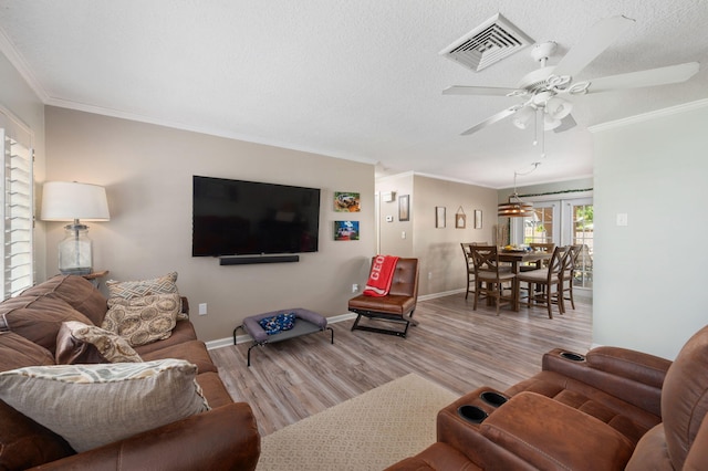 living area featuring visible vents, a textured ceiling, and wood finished floors