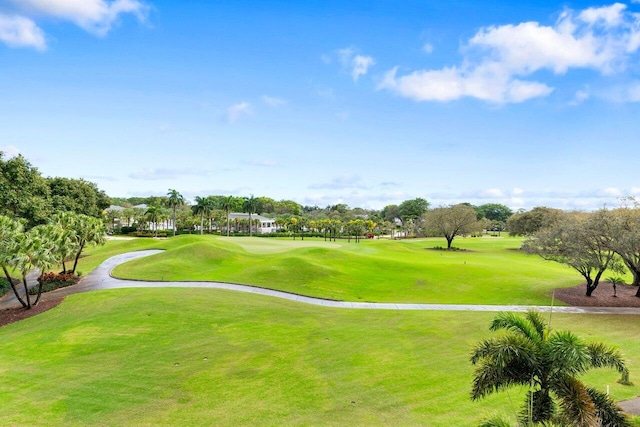 view of property's community with golf course view and a yard