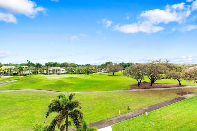 view of community with a yard and golf course view