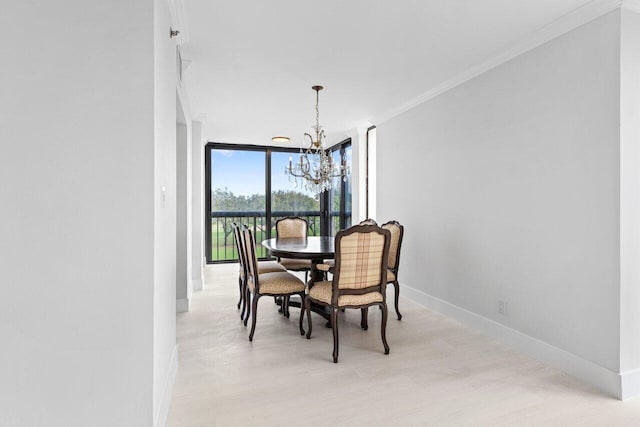 dining room with baseboards, a chandelier, floor to ceiling windows, ornamental molding, and light wood-style floors