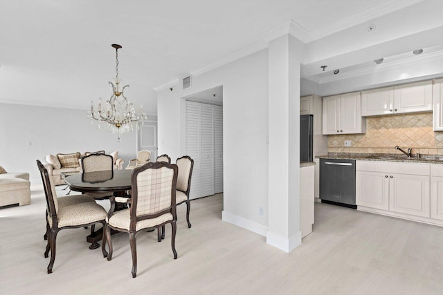 dining space featuring baseboards, an inviting chandelier, light wood-style flooring, and ornamental molding